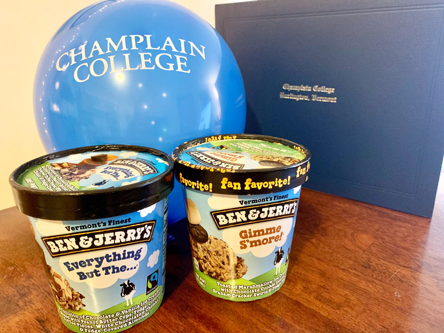 Essential party supplies for Virtual Commencement: blue Champlain College balloon, diploma, and pints of Ben & Jerry's ice cream